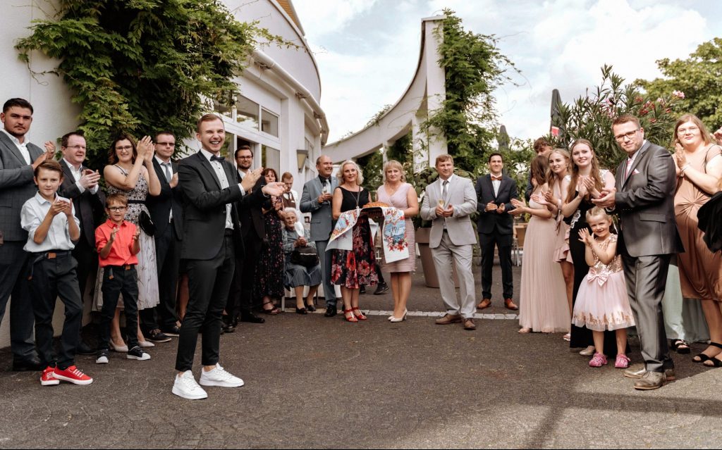 Empfang mit Brot und Salz zusammen mit den Eltern des Brautpaares bei der Eingang von der Hochzeitslocation - Tamada Artem führt elegant eine russische Hochzeit fort