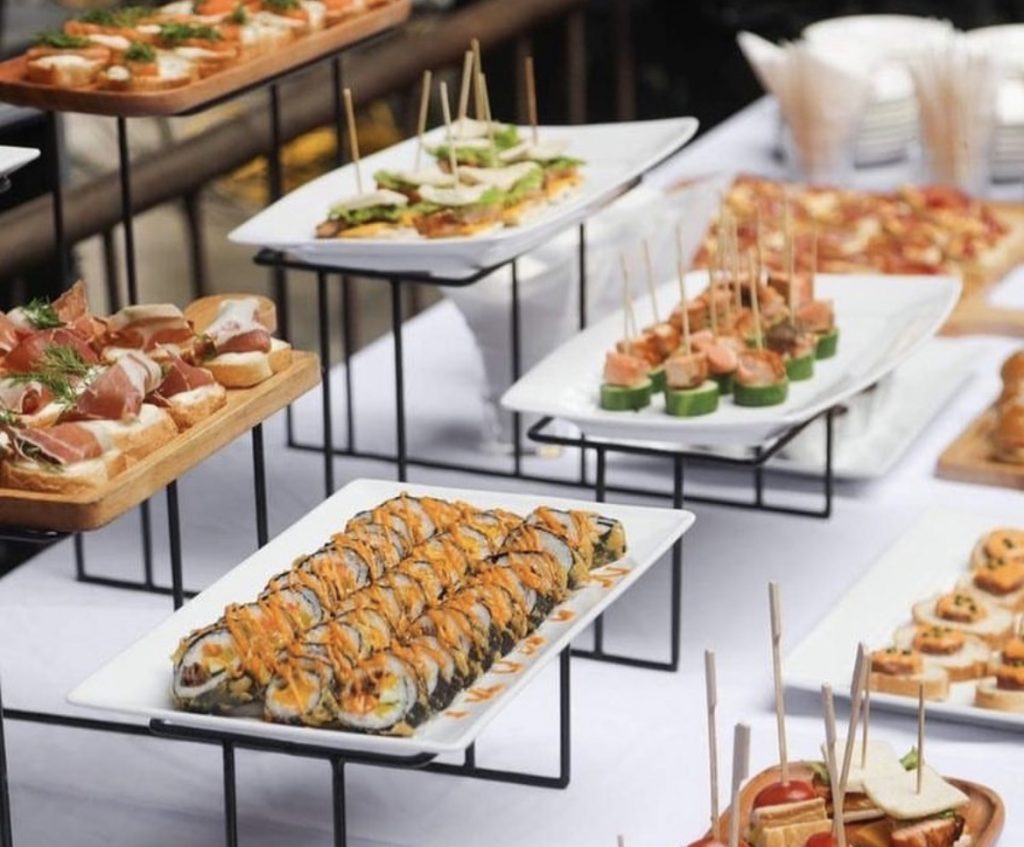 Sushirollen und belegte Häppchen auf verschiedenen Buffetplatten