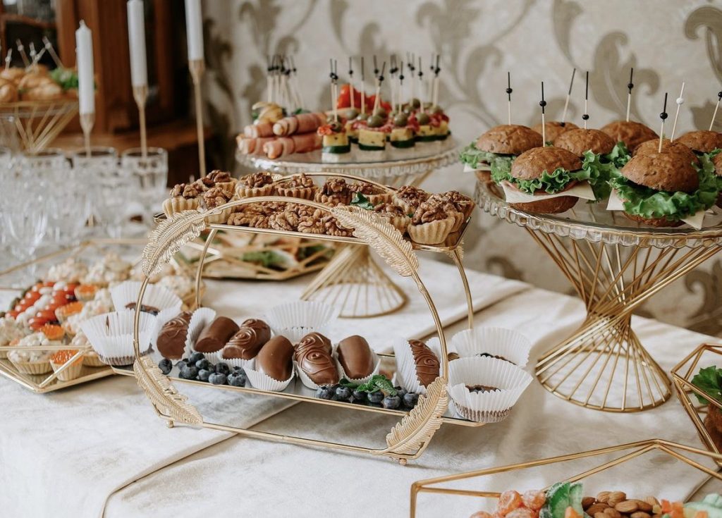 Buffet mit kleinen Burgern, herzhaften Häppchen und süßem Gebäck