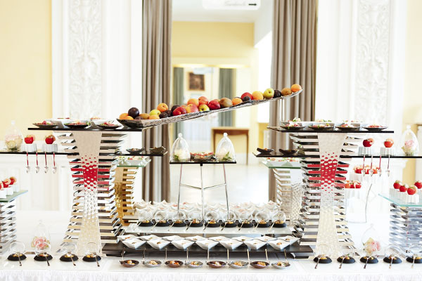 Mehrstufig aufgebautes Fingerfoodbuffet mit kleinen Portionen und Obst
