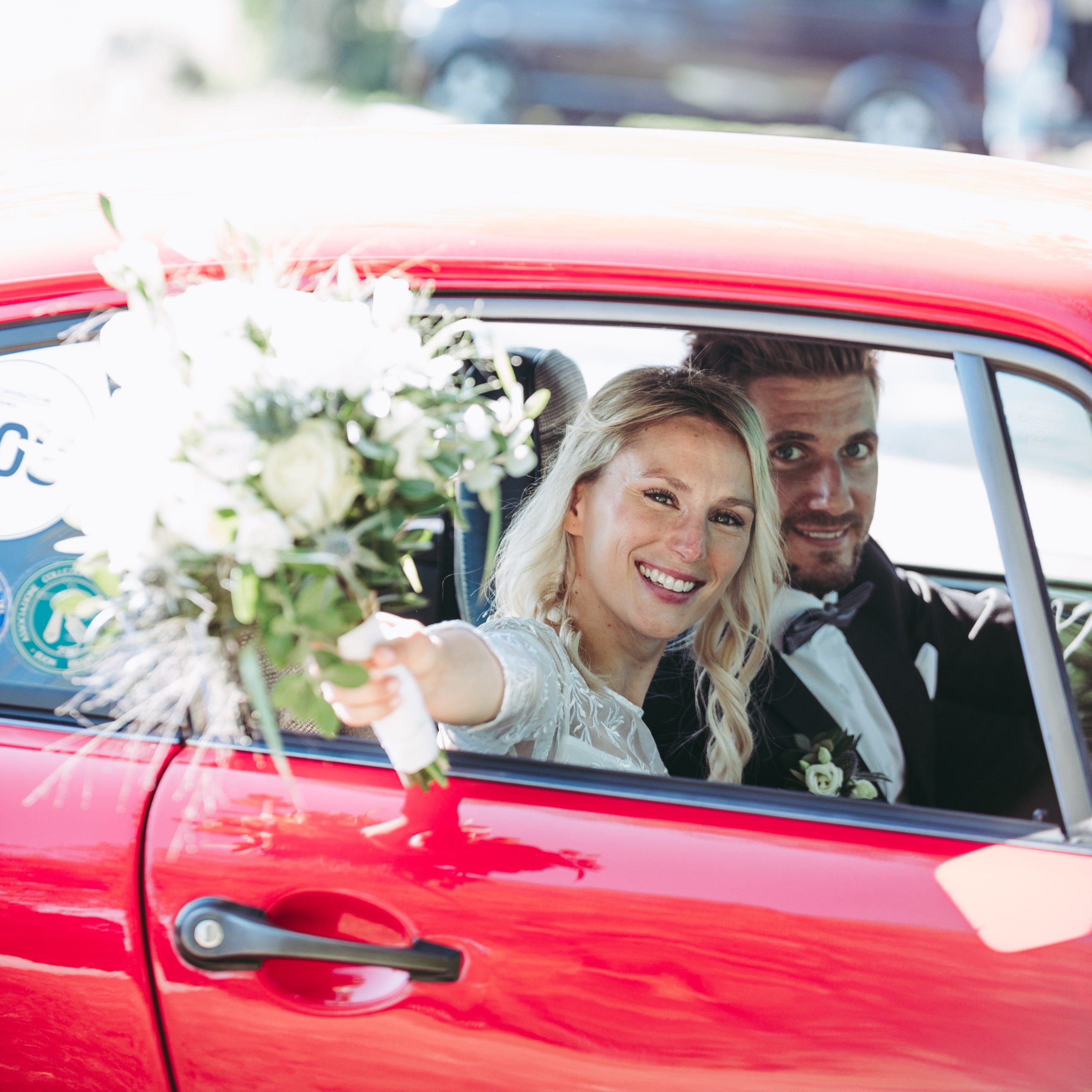 Bayerisches Brautpaar mit dem Auto