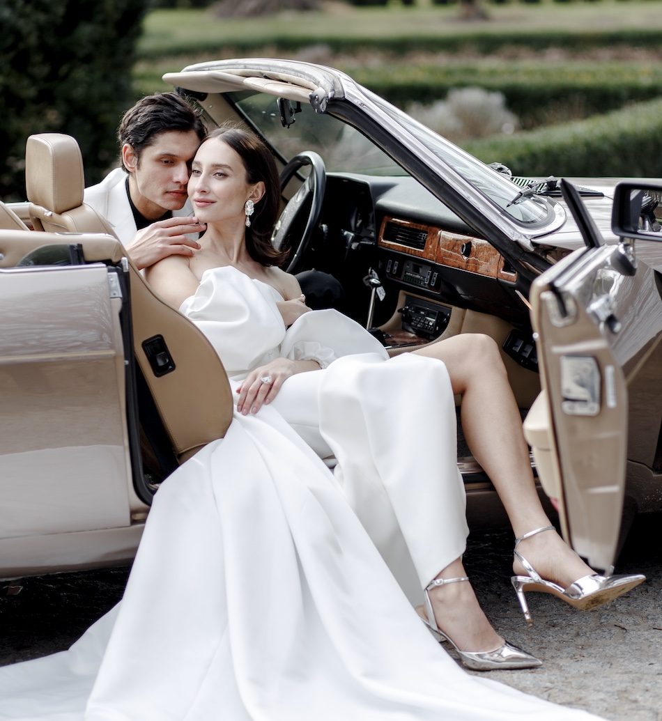 Die Braut umarmt den Bräutigam im Auto während eines romantischen Fotoshootings am Schloss Benrath – ein inniger Moment voller Nähe und Liebe.