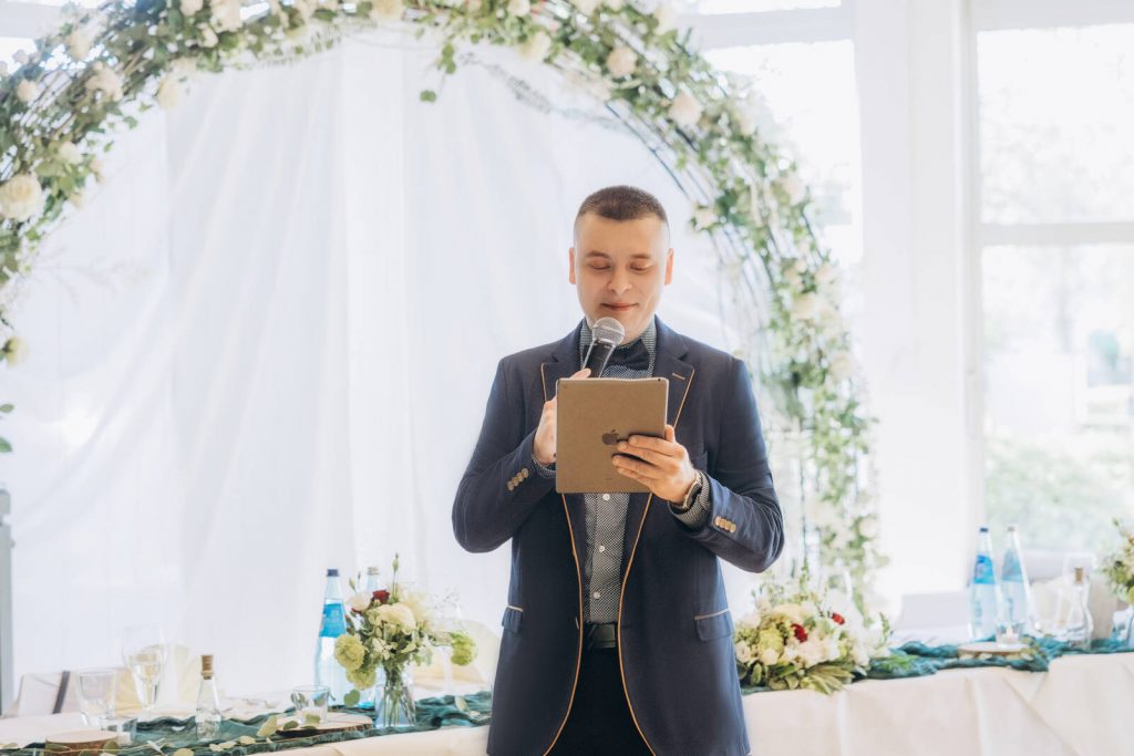 Hochzeitsmoderator Roman liest die Moderation vom Tablet ab bei einer Hochzeit in Nürnberg