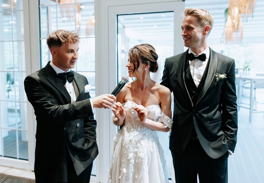 Hochzeitsmoderator und Tamada Johann Sky führt ein Gespräch mit dem Brautpaar während der Hochzeitsfeier.