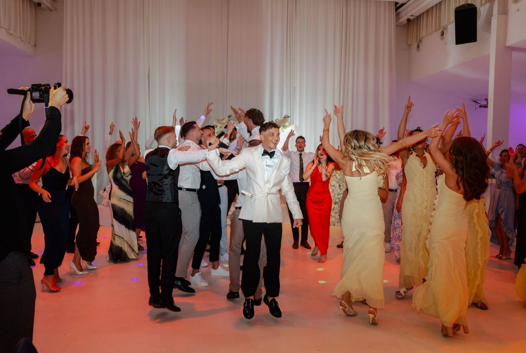 Wedding moderator and Tamada Johann Sky coordinating a joint dance activity with all wedding guests on the dance floor in Germany.