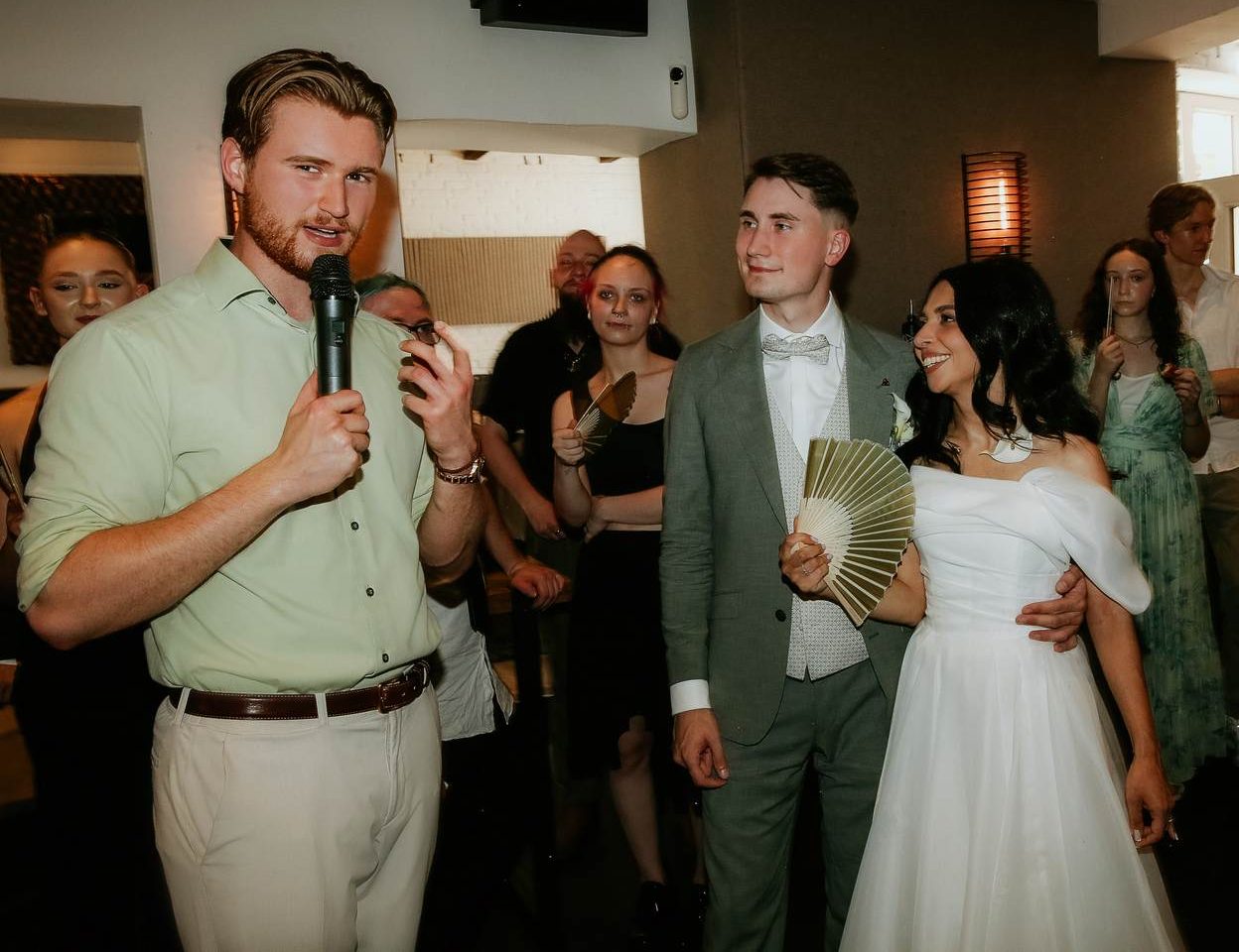 Hochzeitsmoderator Sanja aus Dortmund moderiert mit Mikrofon die Hochzeitsfeier neben dem Brautpaar Hochzeitsmoderator Sanja aus Dortmund moderiert mit Mikrofon die Hochzeitsfeier neben dem Brautpaar