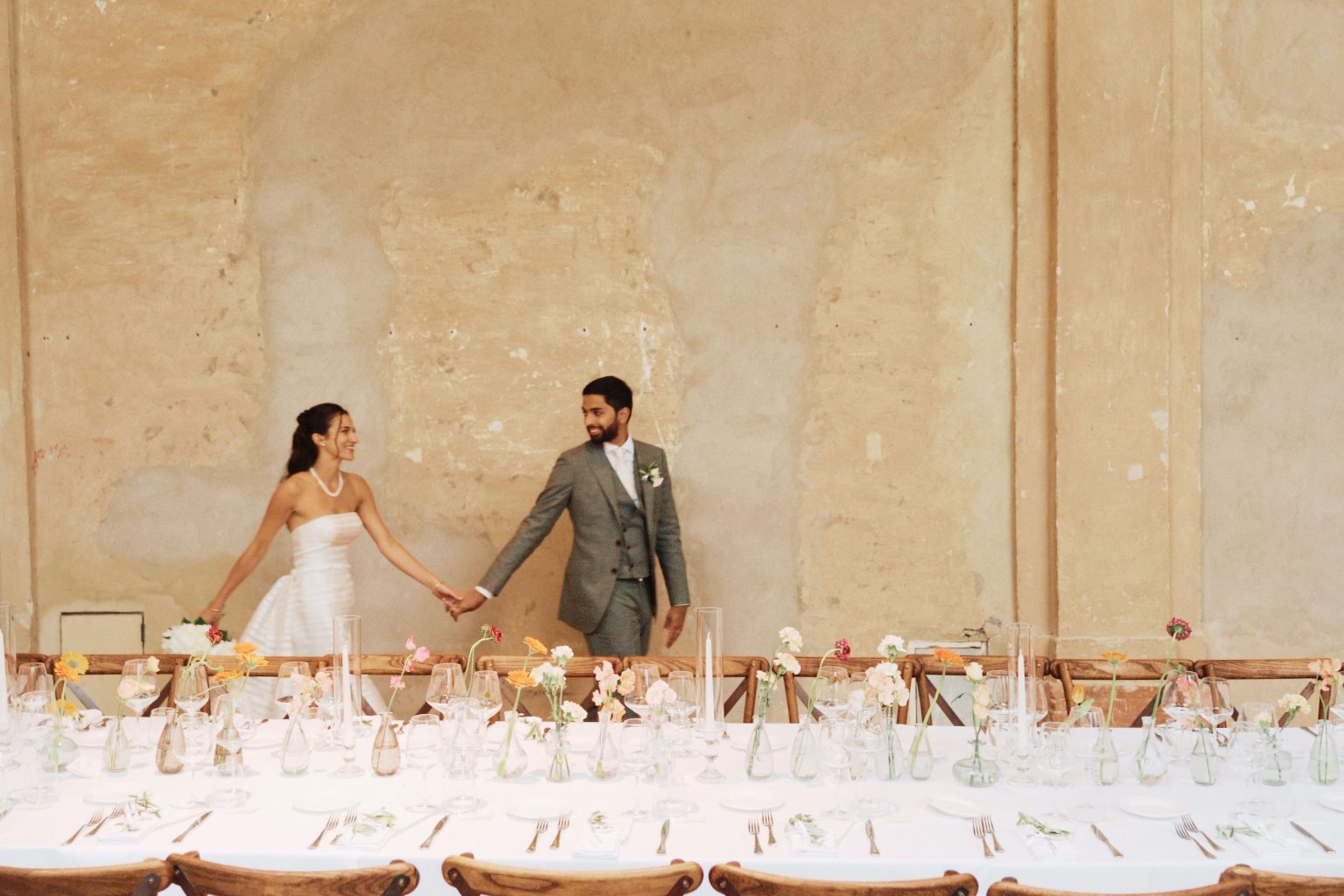 Brautpaar an einer festlich gedeckten Hochzeitstafel mit persönlichen Gastgeschenken