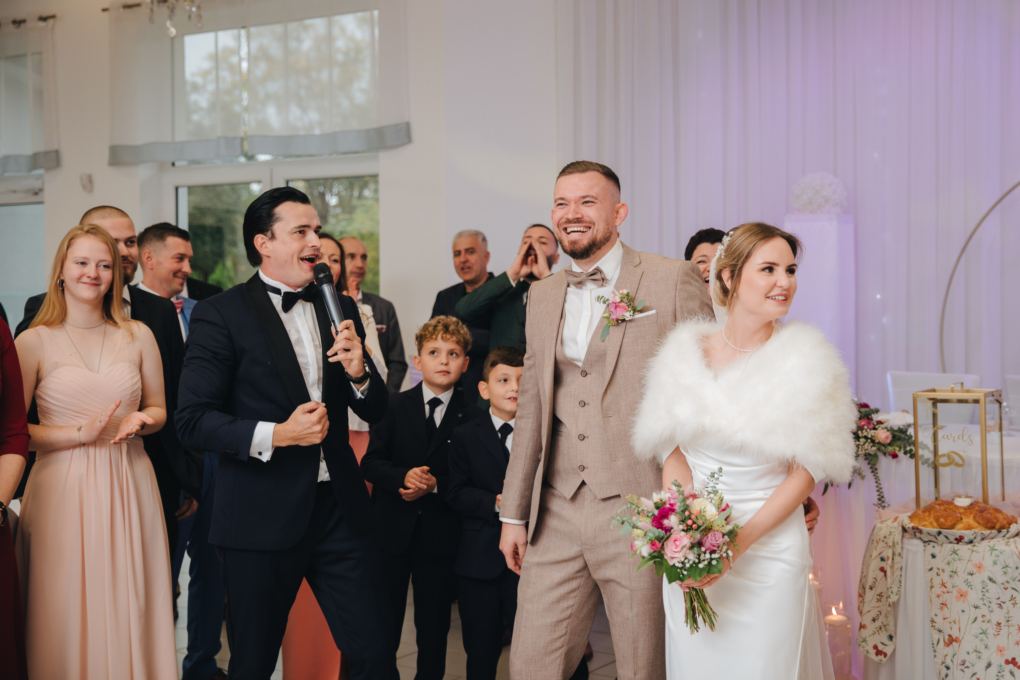 Der Tamada begrüßt das Brautpaar beim feierlichen Einzug in den Hochzeitssaal und sorgt für eine festliche Stimmung vor den Gästen.