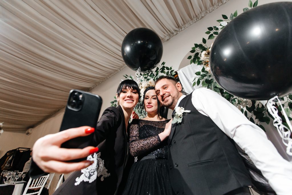 Elena macht ein Selfie mit einem Brautpaar