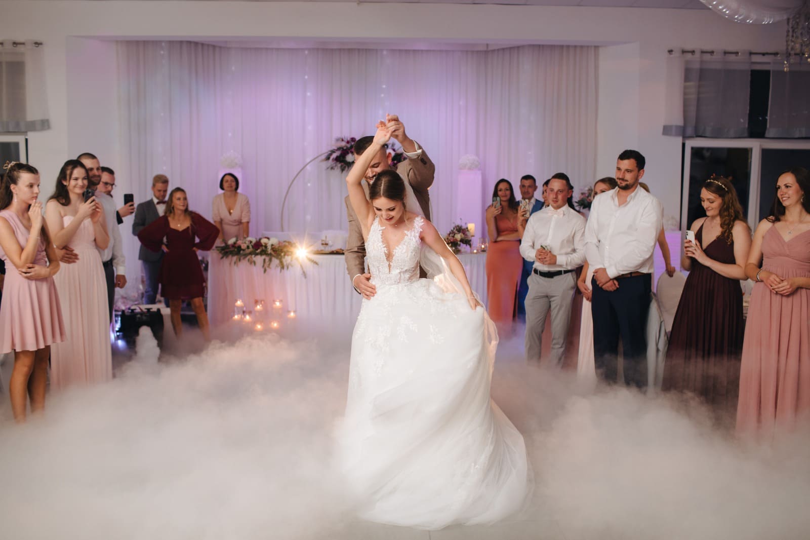 Brautpaar tanzt ersten Hochzeitstanz im Nebel mit Tamada Moderation.