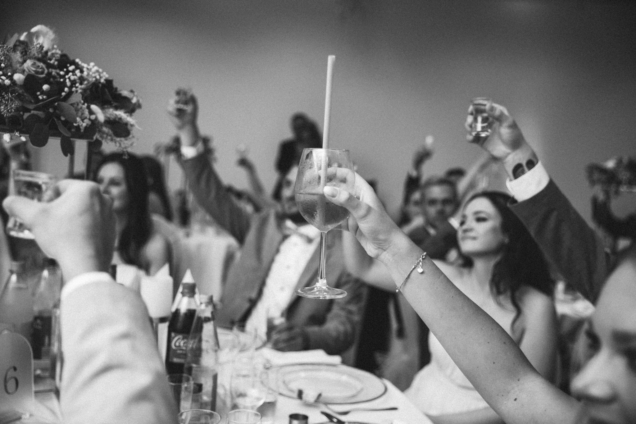 Gäste stoßen beim Hochzeitsdinner gemeinsam an und genießen die entspannte Abendstimmung