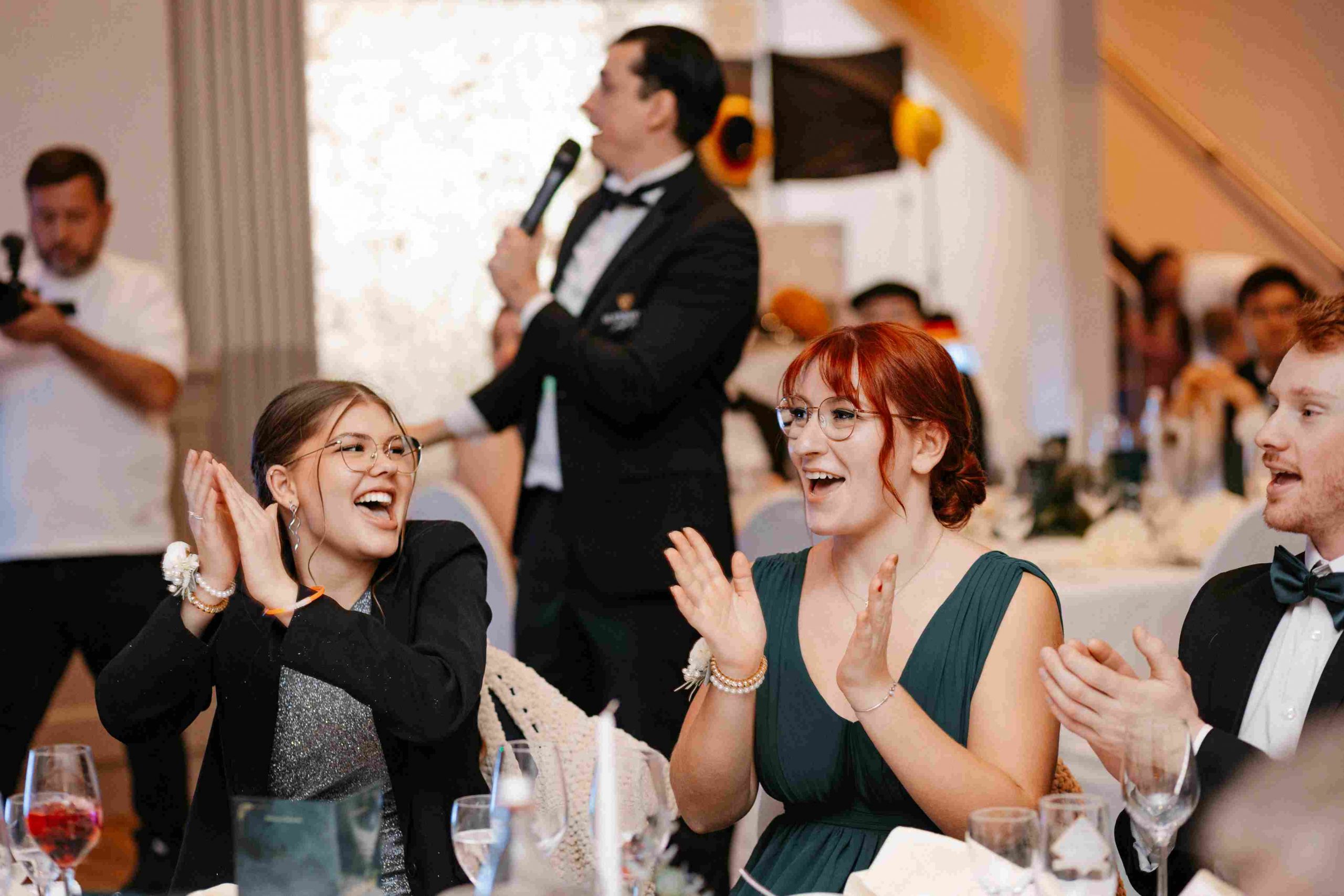 Ein Tamada moderiert eine Hochzeit und sorgt für begeisterte Gäste, die lachen und applaudieren