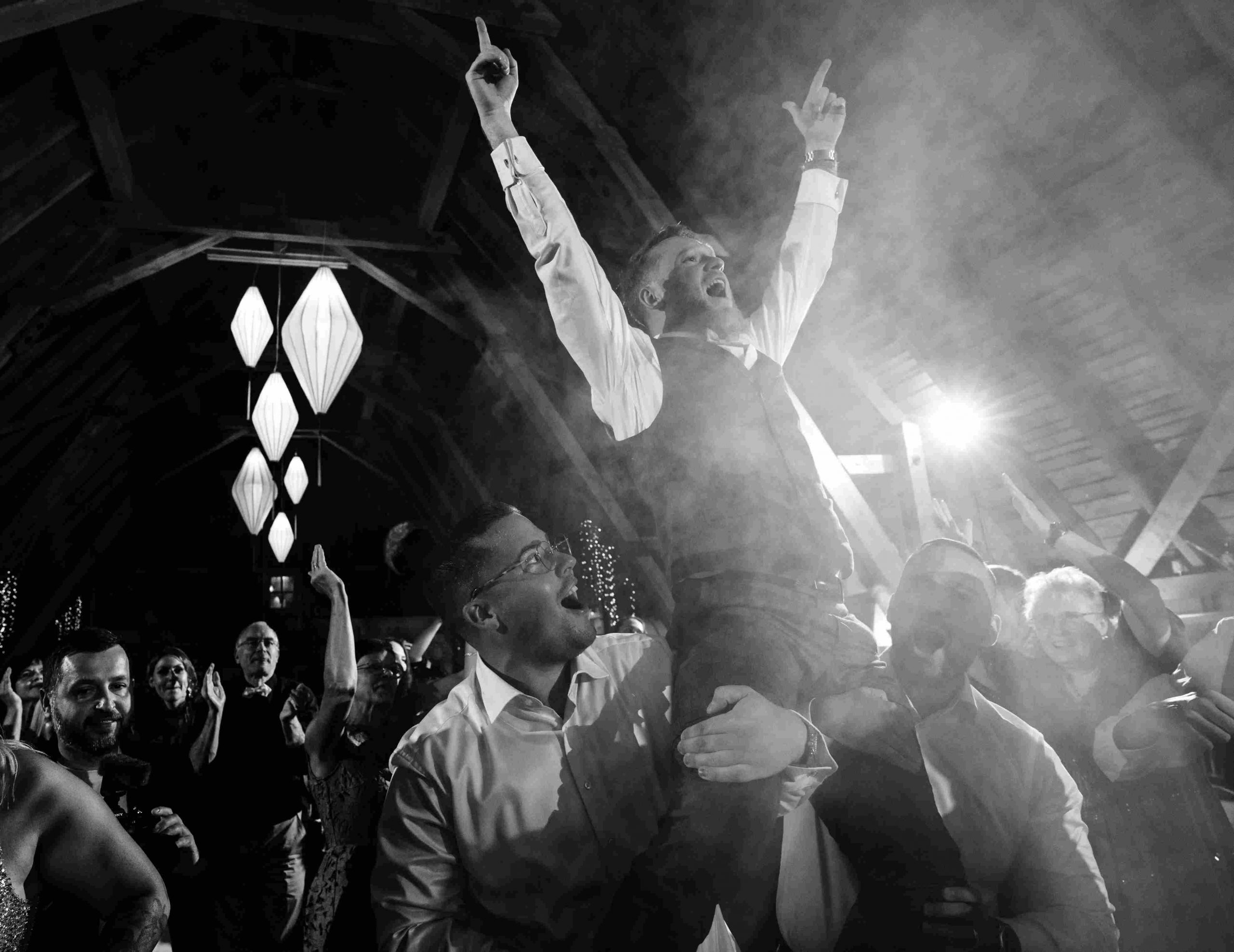 Tamada feiert mit Hochzeitsgästen auf der Tanzfläche und sorgt für ausgelassene Stimmung bei einer Hochzeit