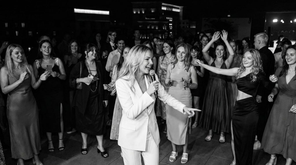 Tamada Yulia auf der Tanzfläche – Hochzeitsmoderatorin mit Mikrofon sorgt für Stimmung unter den Gästen