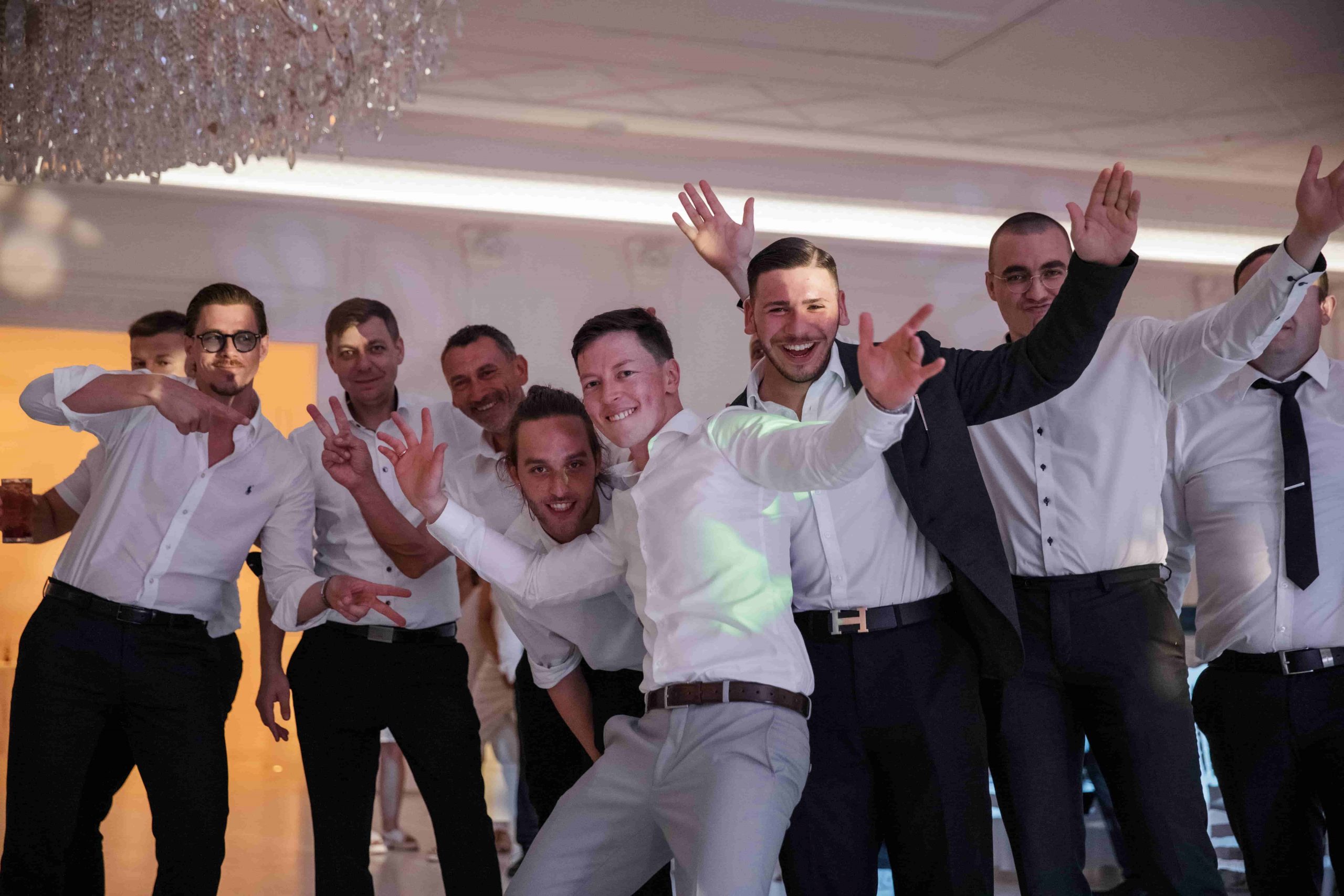 Freunde feiern ausgelassen auf der Tanzfläche einer russisch-deutschen Hochzeit in Berlin während der Abendparty
