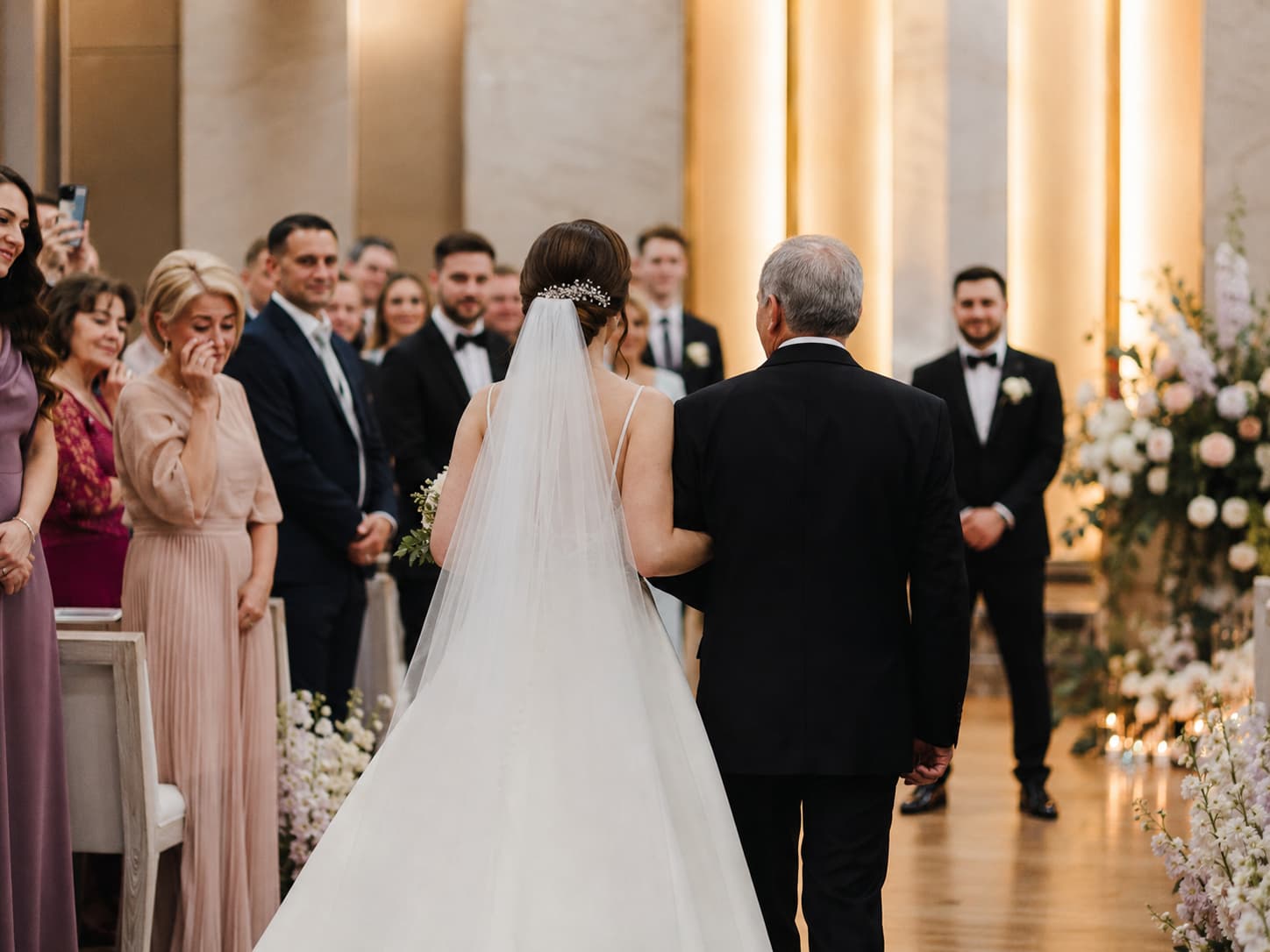 Braut zieht mit ihrem Vater bei einer russisch-deutschen Hochzeit in München in den Hochzeitssaal ein.
