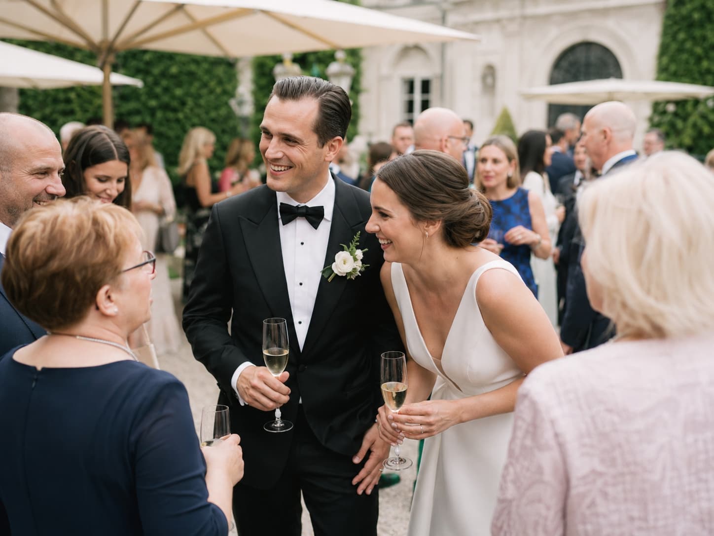 Brautpaar begrüßt Gäste beim Sektempfang einer russisch-deutschen Hochzeit in München.