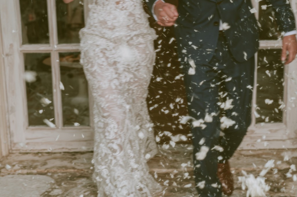 Braut und Bräutigam feiern ihre deutsch-italienische Hochzeit unter einem romantischen Federregen.