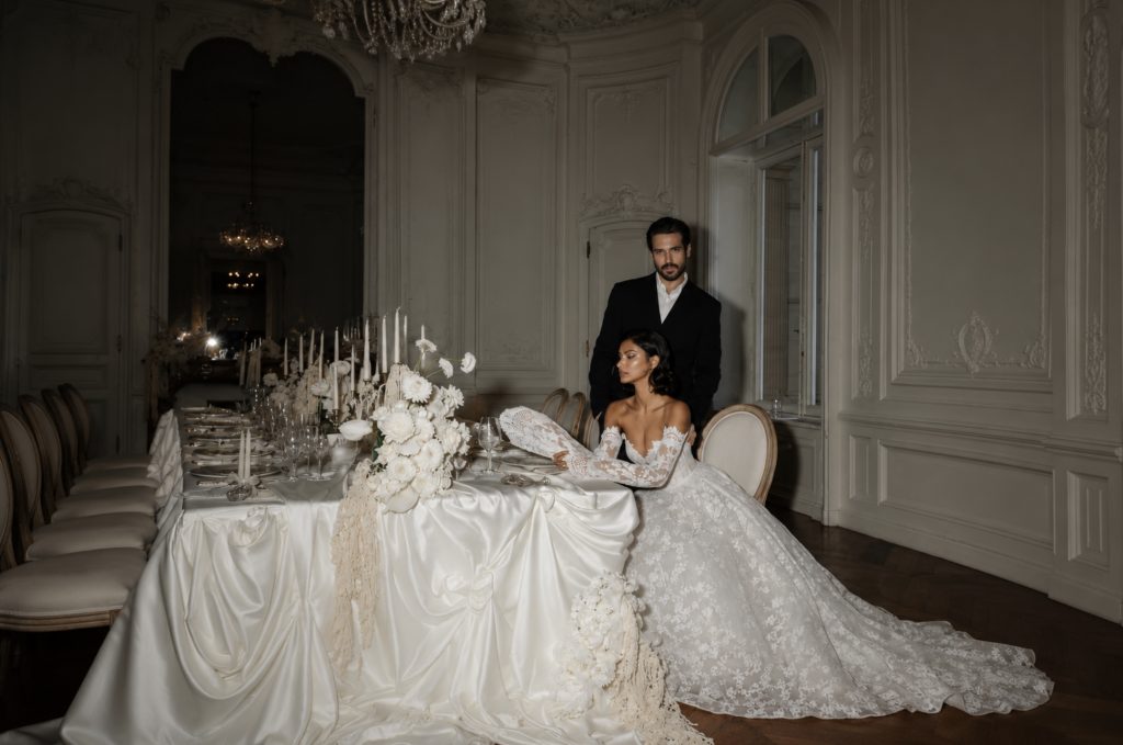 Luxuriöse Hochzeitstafel mit Brautpaar in einem eleganten Schloss.