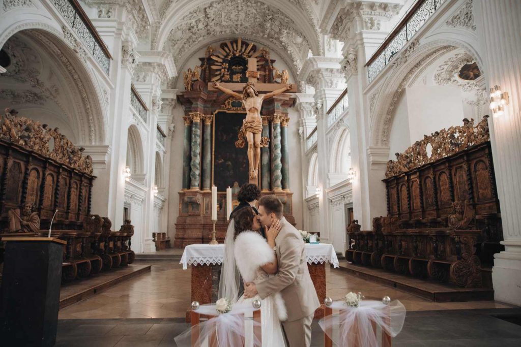 Brautpaar küsst sich am Altar während der kirchlichen Trauung in Frankfurt