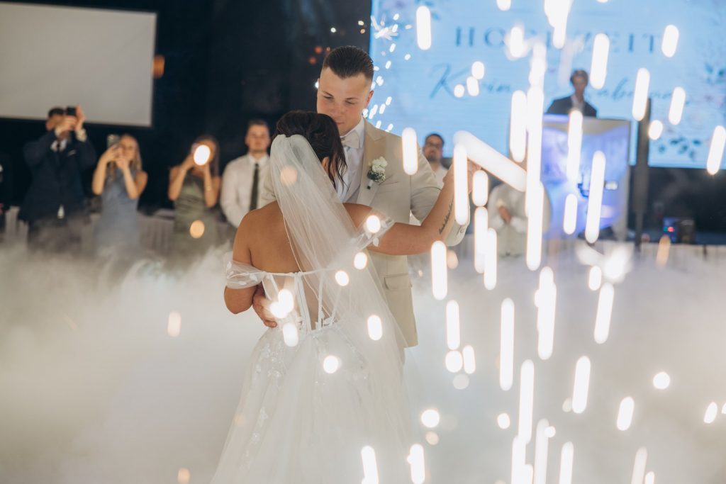 Brautpaar tanzt eng umschlungen zwischen leuchtenden Funkenfontänen und Bodennebel beim ersten Tanz einer Hochzeit in Köln