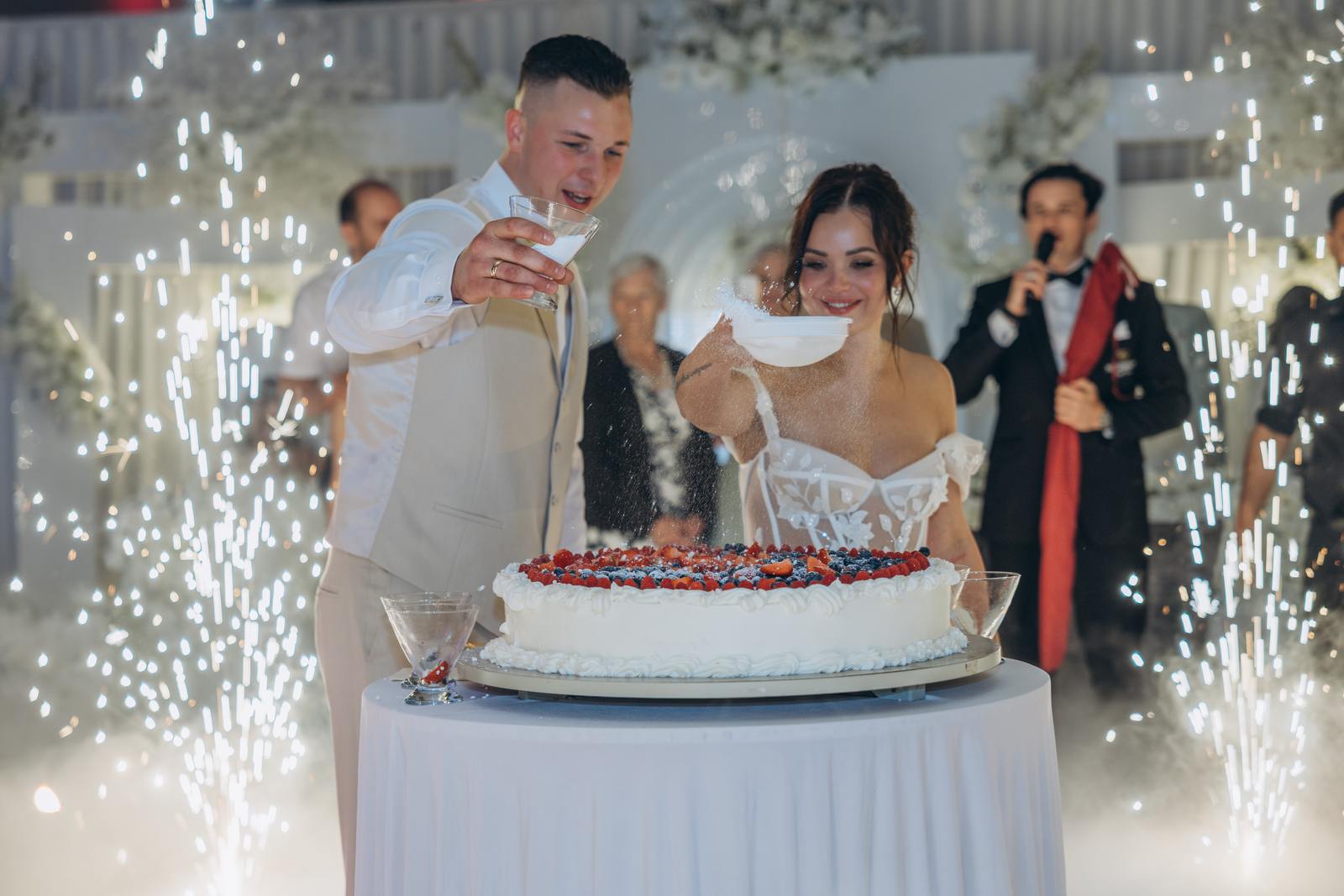 Brautpaar schneidet die Hochzeitstorte im Funkenregen bei der Hochzeit in Köln an