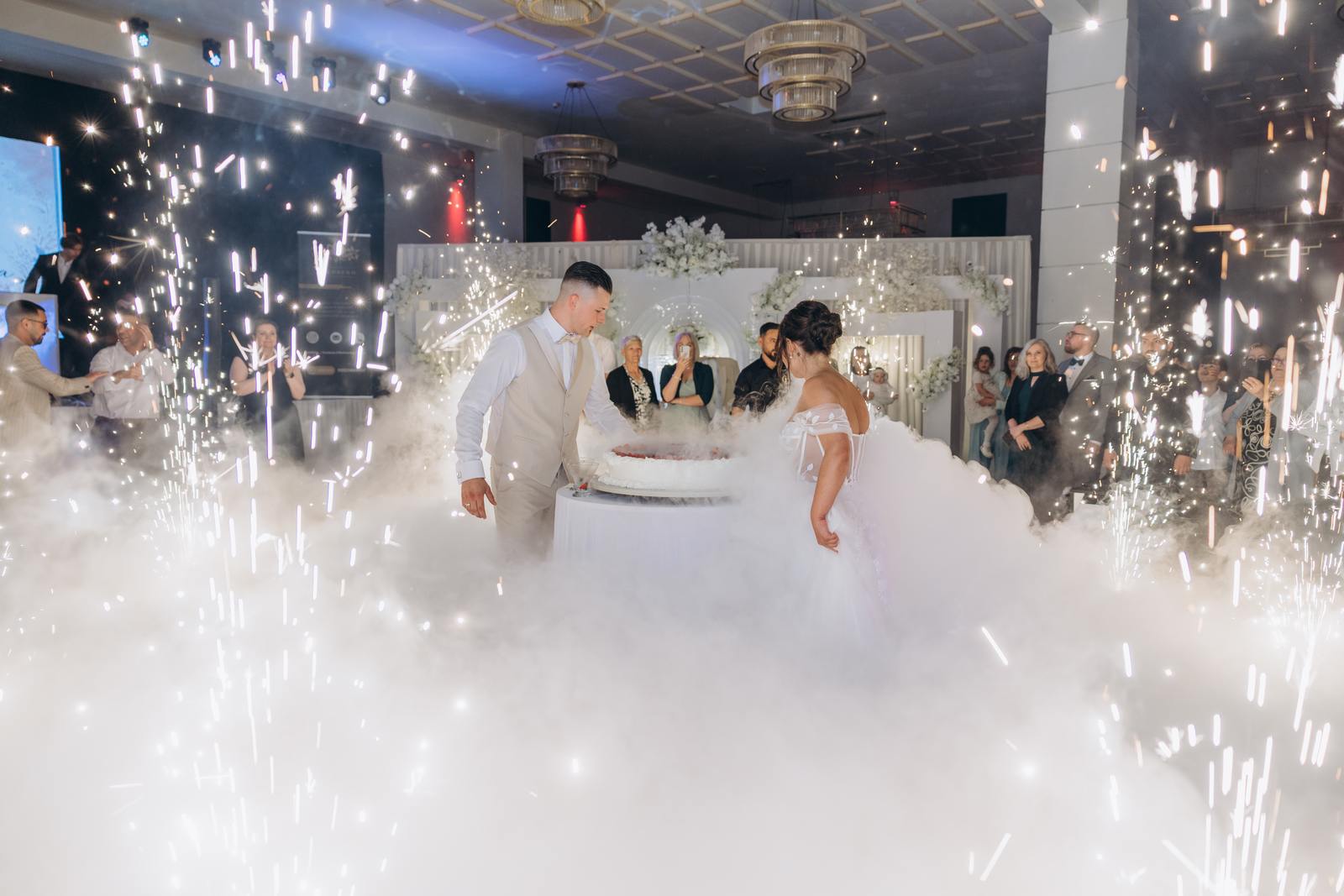 Brautpaar steht am Tortentisch im dichten Bühnennebel bei der Hochzeit in Köln