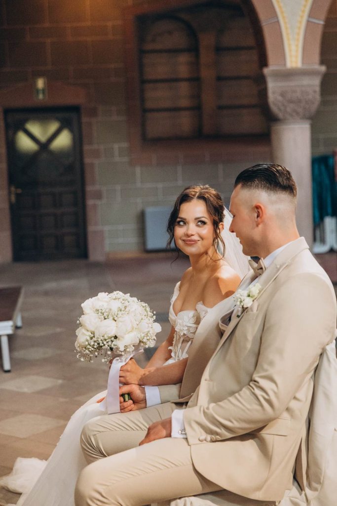 Brautpaar folgt beim Auszug aus der Kirche zwei Blumenkindern mit Körbchen und Blumenkränzen, Hochzeit in Köln
