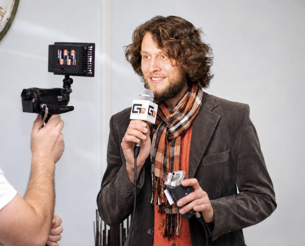 Hochzeitsmoderator Jonny gibt ein Interview mit Mikrofon und begeistert mit seiner offenen und sympathischen Ausstrahlung.