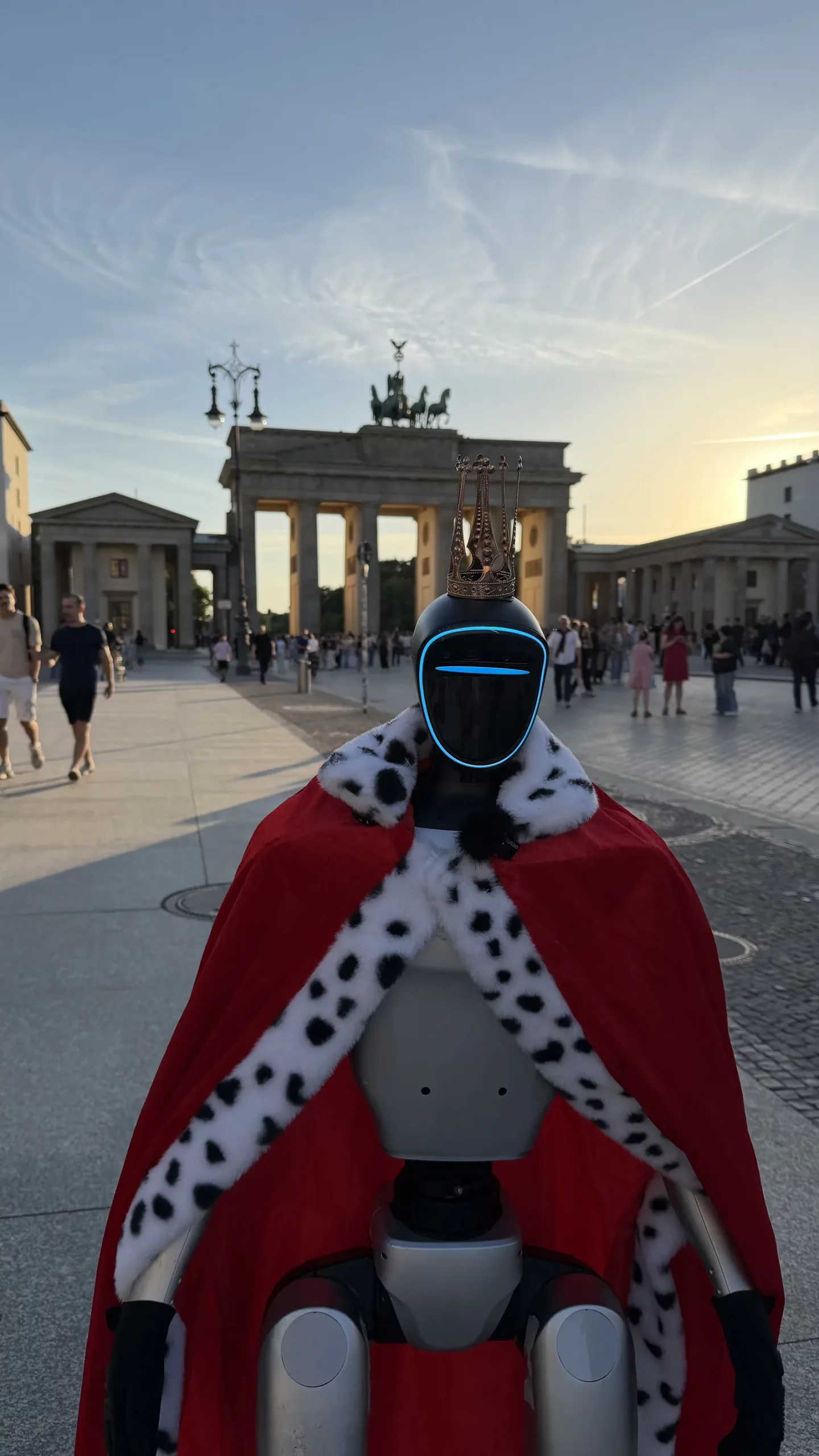 Humanoider Roboter-König im Krönungsmantel vor dem Brandenburger Tor in Berlin