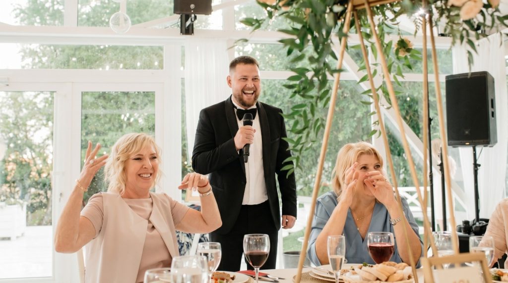 Tamada Demy moderiert mit Humor – Gäste lachen am Hochzeitstisch