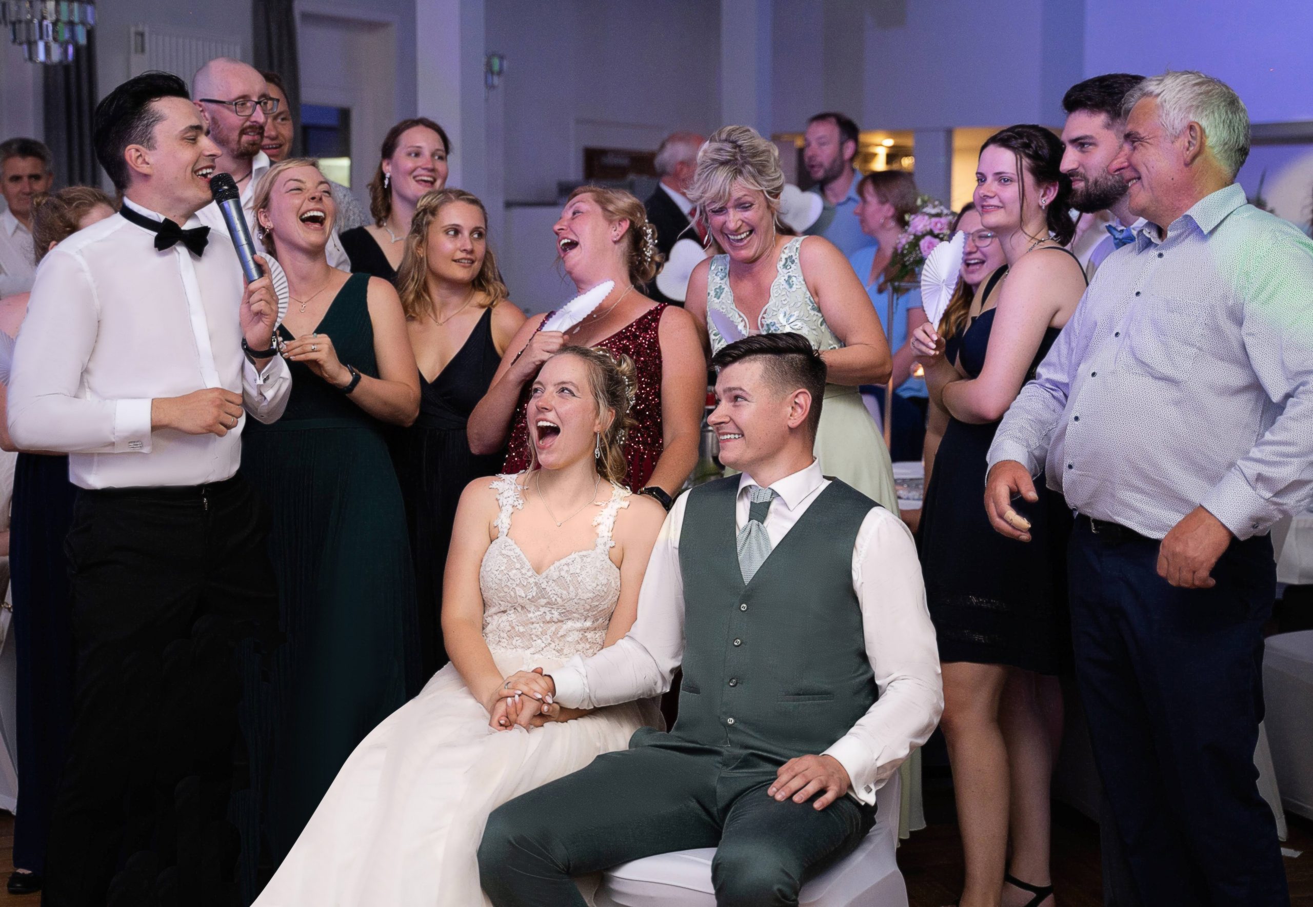 Tamada moderiert – Brautpaar und Gäste lachen bei der Hochzeit 2026