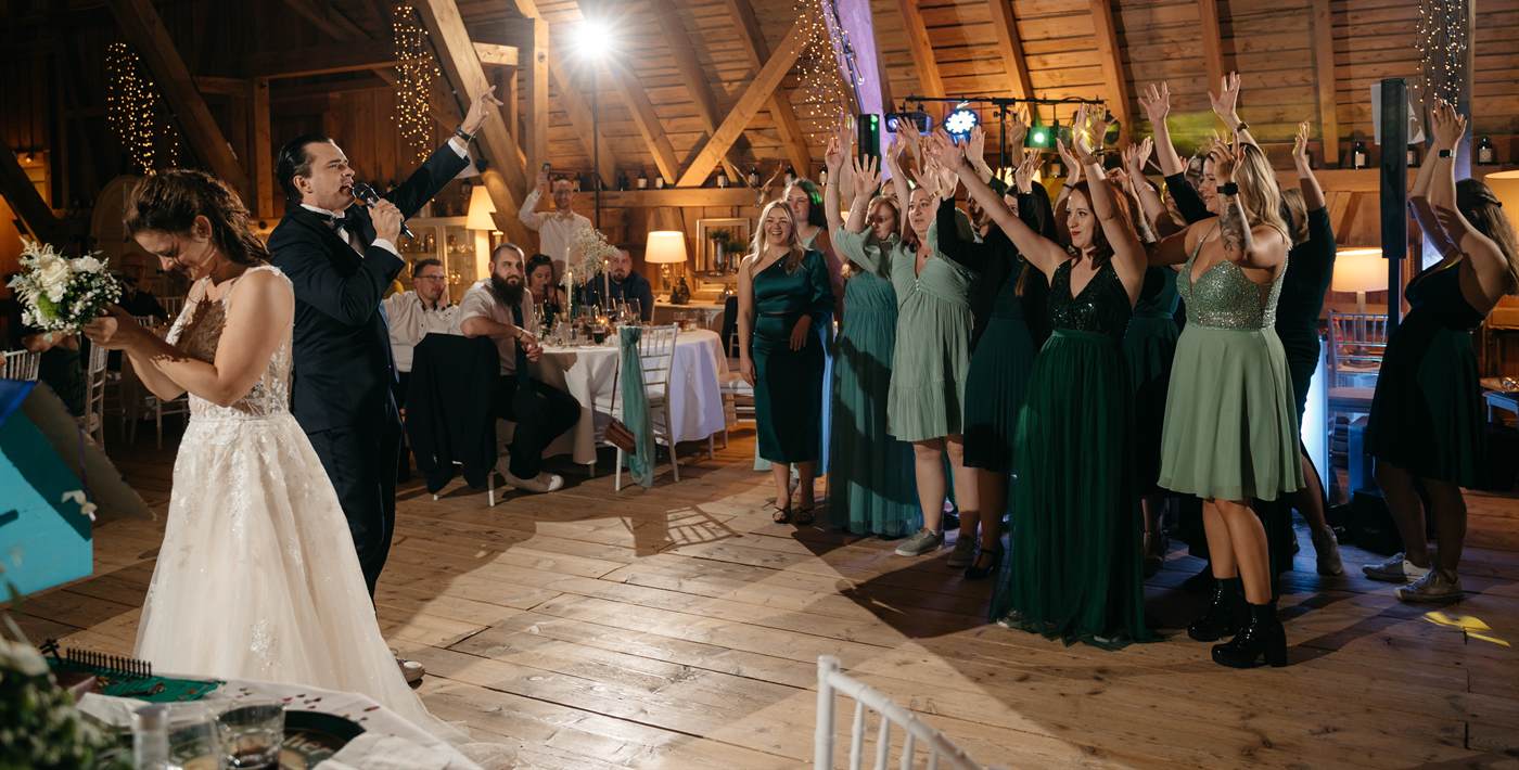 Straußwurf auf der Hochzeit – die Braut wirft den Brautstrauß, Gäste strecken jubelnd die Hände hoch 2026