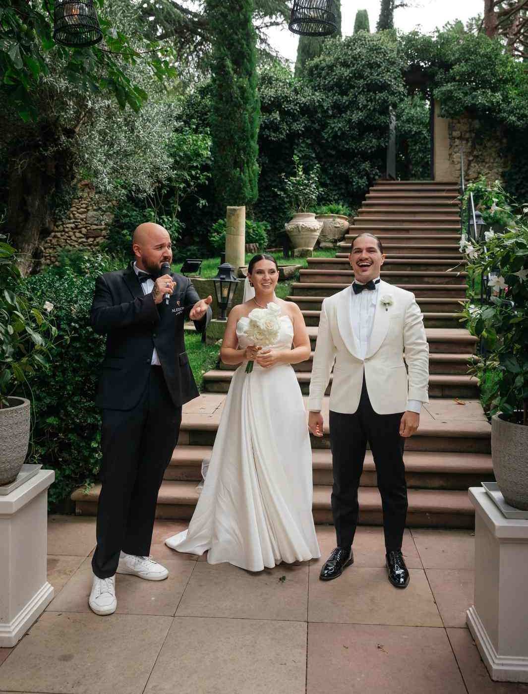 Hochzeitsmoderator Vincent mit Brautpaar im Garten Hochzeitsmoderator Vincent mit Mikrofon neben dem Brautpaar auf einer Gartentreppe