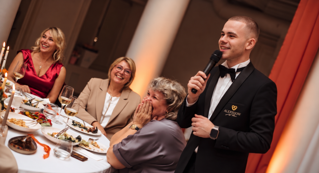 Tamada Luca bringt Hochzeitsgäste am festlich gedeckten Tisch zum Lachen