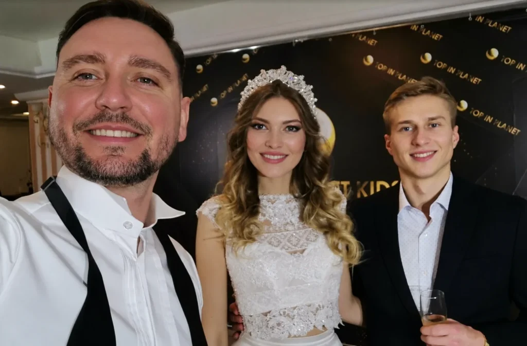 Sergey Solovyov mit einem lächelnden Brautpaar bei einer Hochzeitsfeier.
