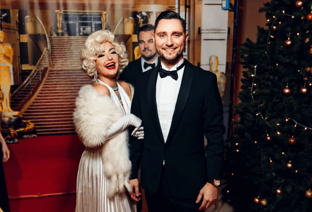 Sergey Solovyov im Smoking neben einer Künstlerin im Marilyn-Monroe-Stil bei einer Gala.